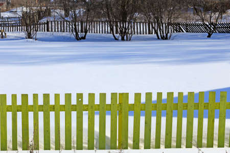isolated rustic fence on the white snow in winterの写真素材