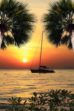seascape scenic sunset and anchored boat with deflated sails off the coast of Thailandの写真素材