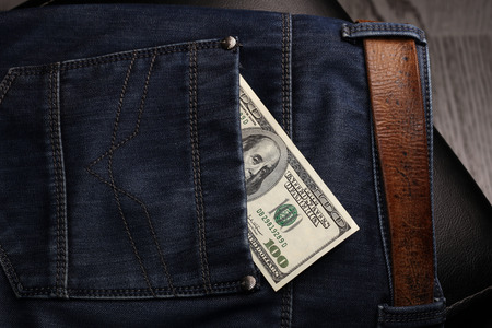 close-up of dollar bills pocket denim trousers, studio