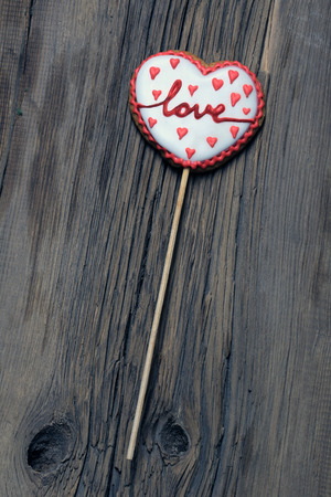 close-up ginger biscuits in the shape of hearts and men on the background of an old treeの写真素材