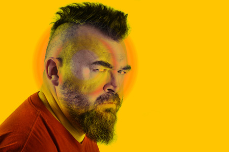 close-up portrait profile of a angry white man with mohawk and beardの写真素材