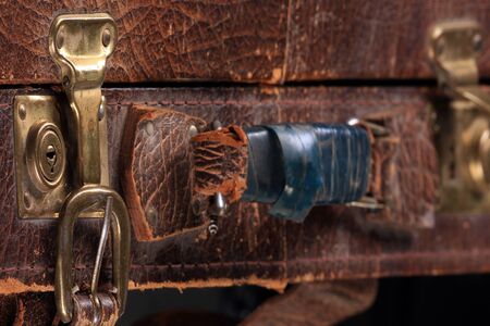 close-up fragment of locks and fasteners on the vintage leather suitcase brownの写真素材