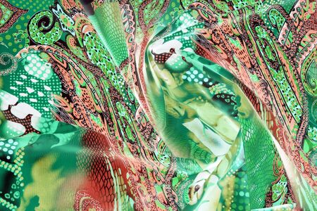 close-up fragment of fabric with oriental ornament violet-blue-pink color
