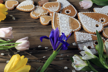 macro gingerbread heart-shaped with a yellow ribbon, flowers on wood background studioの写真素材
