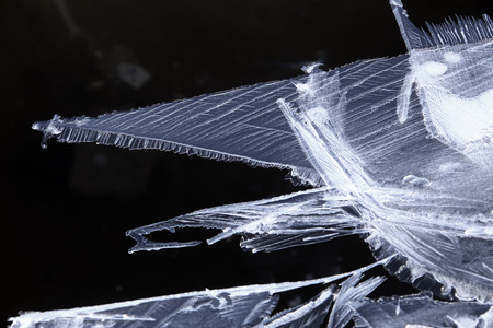 macro isolated texture of of fine ice crystals against a dark background on the river in early spring in the sunlightの写真素材