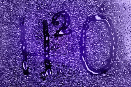 Macro drops on the glass and H2O label, on a purple background studioの写真素材