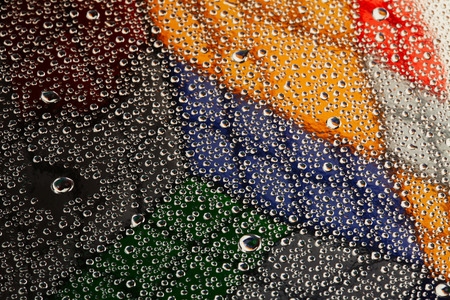 close-up texture water droplets on glass against the backdrop of the Rubik's Cubeの写真素材