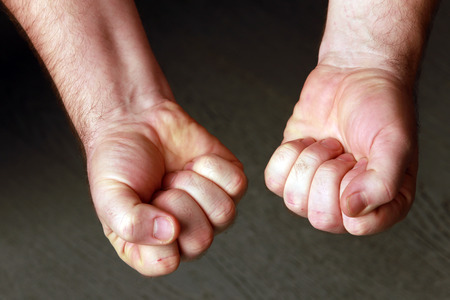 close-up man's fist on a gray background studioの写真素材