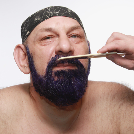 close-up portrait of an adult male in bandana when dyeing beards and mustache on white background studioの写真素材
