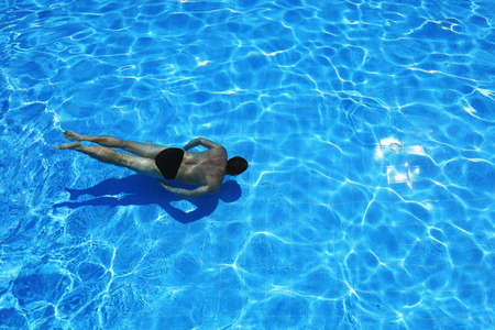 isolated azure water pool and swimmer in the waterの写真素材