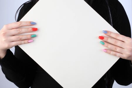 poster in the hands of the girl with painted colored nailsの写真素材