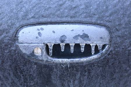 closeup fragment of the ice-covered car in the sun frosty morningの写真素材