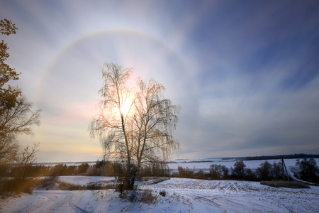 winter landscape snow-covered fields, trees and roads in sunlight raysの写真素材