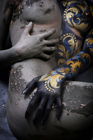 nude body fragment of a young girl with body painted in Khokhloma style in the art of body art using airbrush and clayの写真素材