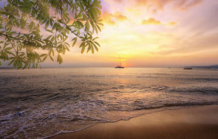 seascape scenic sunset and anchored boat with deflated sails off the coast of Thailandの写真素材
