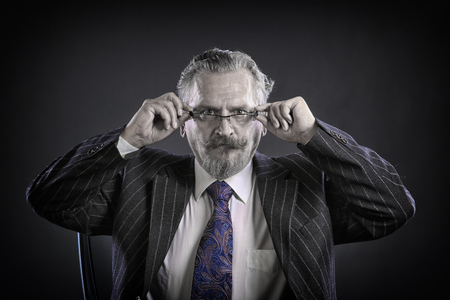closeup portrait of an adult male with a mustache and beard, wearing glasses and a business suit studioの写真素材