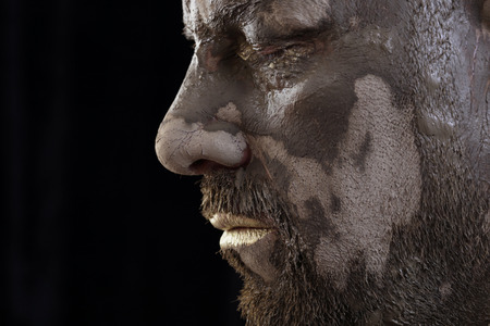 close-up portrait of a man in the clay body art , studio on a dark backgroundの写真素材