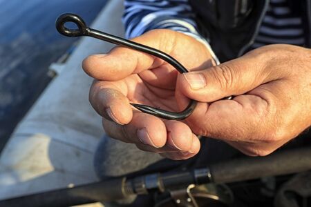 macro large fishing hook against the background of the palm of a fisherman