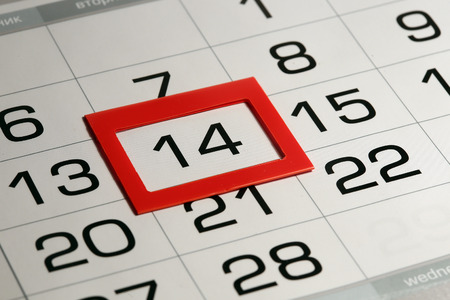 macro texture background page of calendar with date of 14 selected red pointerの写真素材