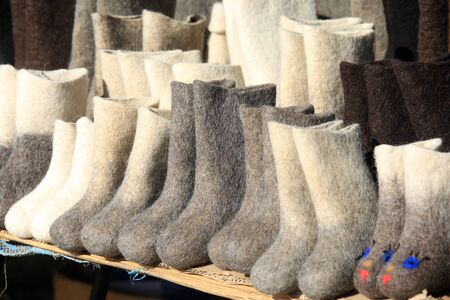 isolated close-up of multiple pairs of felt boots in various colors and sizesの写真素材