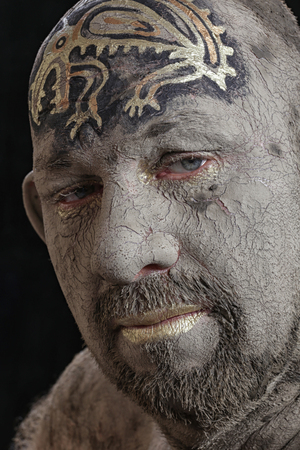 close-up portrait of a man in the clay body art , studio on a dark backgroundの写真素材
