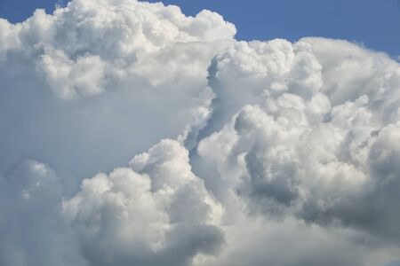background beautiful fluffy white clouds on a blue sky on a sunny dayの写真素材