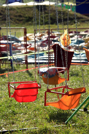 closeup colored swing on the chain in the sunlightの写真素材