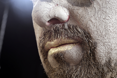 close-up portrait of a man in the clay body art , studio on a dark backgroundの写真素材