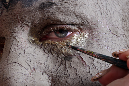 close-up portrait of a man in the clay body art , studio on a dark backgroundの写真素材