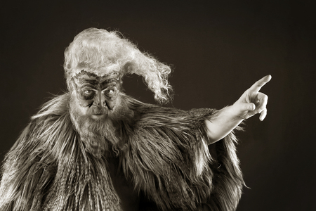 closeup portrait face-art shabby rooster of an adult red-haired man with long disheveled hair and beardの写真素材