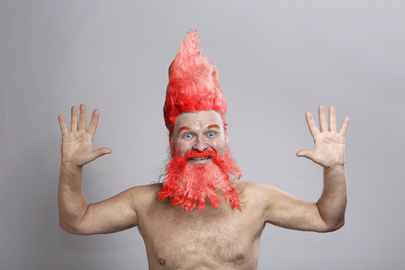 closeup portrait of a charismatic adult man with a beard and high mohawk in the studio on a gray backgroundの写真素材
