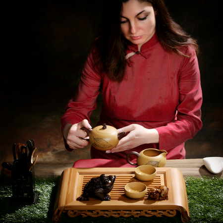 close-up portrait girl of a tea master in the studio against a dark backgroundの写真素材