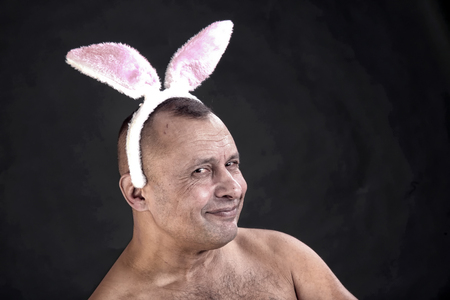 funny portrait of a man with a pink rabbit ears on gray background studioの写真素材