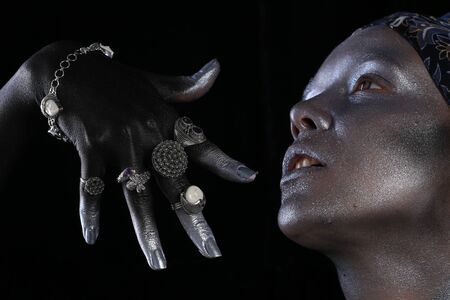 Macro silver jewelry in female hands model body art on black backgroundの写真素材