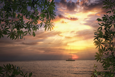 seascape scenic sunset and anchored boat with deflated sails off the coast of Thailandの写真素材