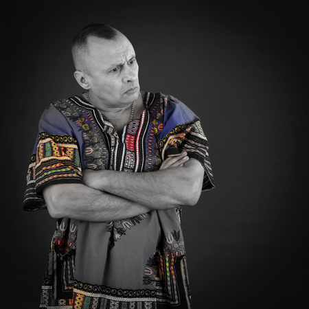Portrait of a charismatic man in ethnic color shirt on a gray background studio