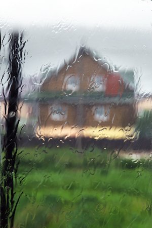 Rain on a transparent window outside the cityの写真素材