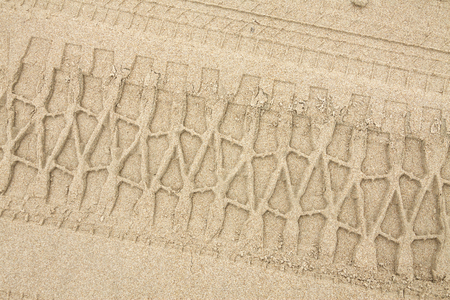 car wheel tires print footprint on the beach gray sandの写真素材