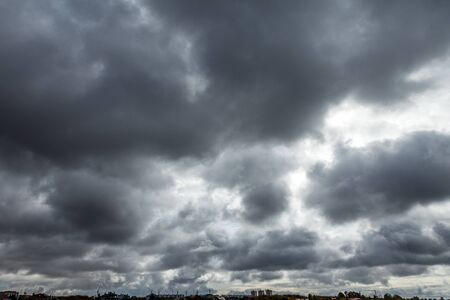 Full frame of dramatic sky with clouds with skyline and urban landscape.の写真素材
