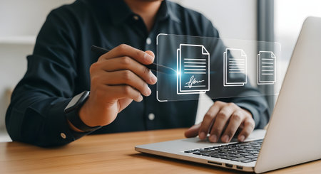 Businessman working on laptop computer with document icon diagram on screen.の素材