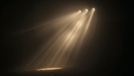 Three overhead stage lights pierce smoky air, casting dramatic golden beams onto an empty stage. The moody, cinematic atmosphere is ideal for theatre, concert, entertainment, and event promotion visuals.の素材
