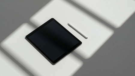 A sleek tablet rests on a bright white surface with a slim stylus nearby. The minimalist, high-contrast composition conveys a modern tech mood ideal for digital design, tech marketing, and productivity-focused visuals.の素材