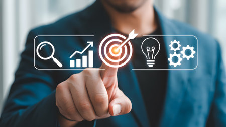 A person's hand points to a digital interface displaying icons for analysis, growth, goals, ideas, and processes.の素材