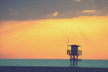 Twilight scenery of a beautiful light house near sea against the red sky