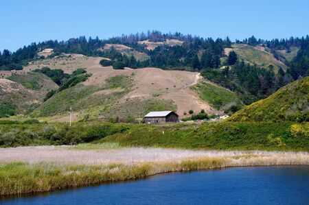 An old barn in the distance sitting beside a California beach.の写真素材