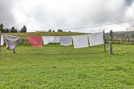 Clothes drying on a clothesline in a meadowの写真素材