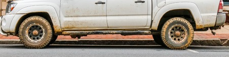 Half view of dirty pickup truck after rain