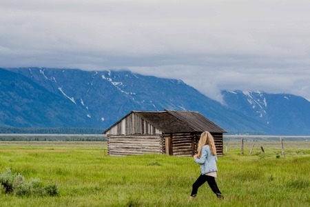 YELLOWSTONE NATIONAL PARK, WYOMING, USA - JUNE 17, 2018: Tourists near the House At Moulton Barns on a prairie grass field. Grand Teton National Park, Wyoming, USAのeditorial素材