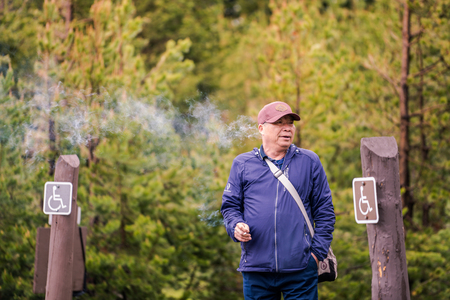 YELLOWSTONE NATIONAL PARK, WYOMING, USA - JUNE 18, 2018: Tourist smoking at Yellowstone National Park, USAのeditorial素材