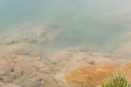 Bubbling hot spring produces sulfur gas in Yellowstone National Park. Water and grasses and steam. Geothermal activity, hot thermal springs with boiling water and fumesの写真素材